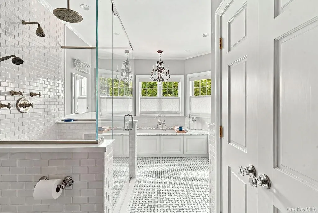 Spa-like primary bath with basket-weave floor and double linen closet Spa-like primary bath with basket-weave floor and double linen closet
