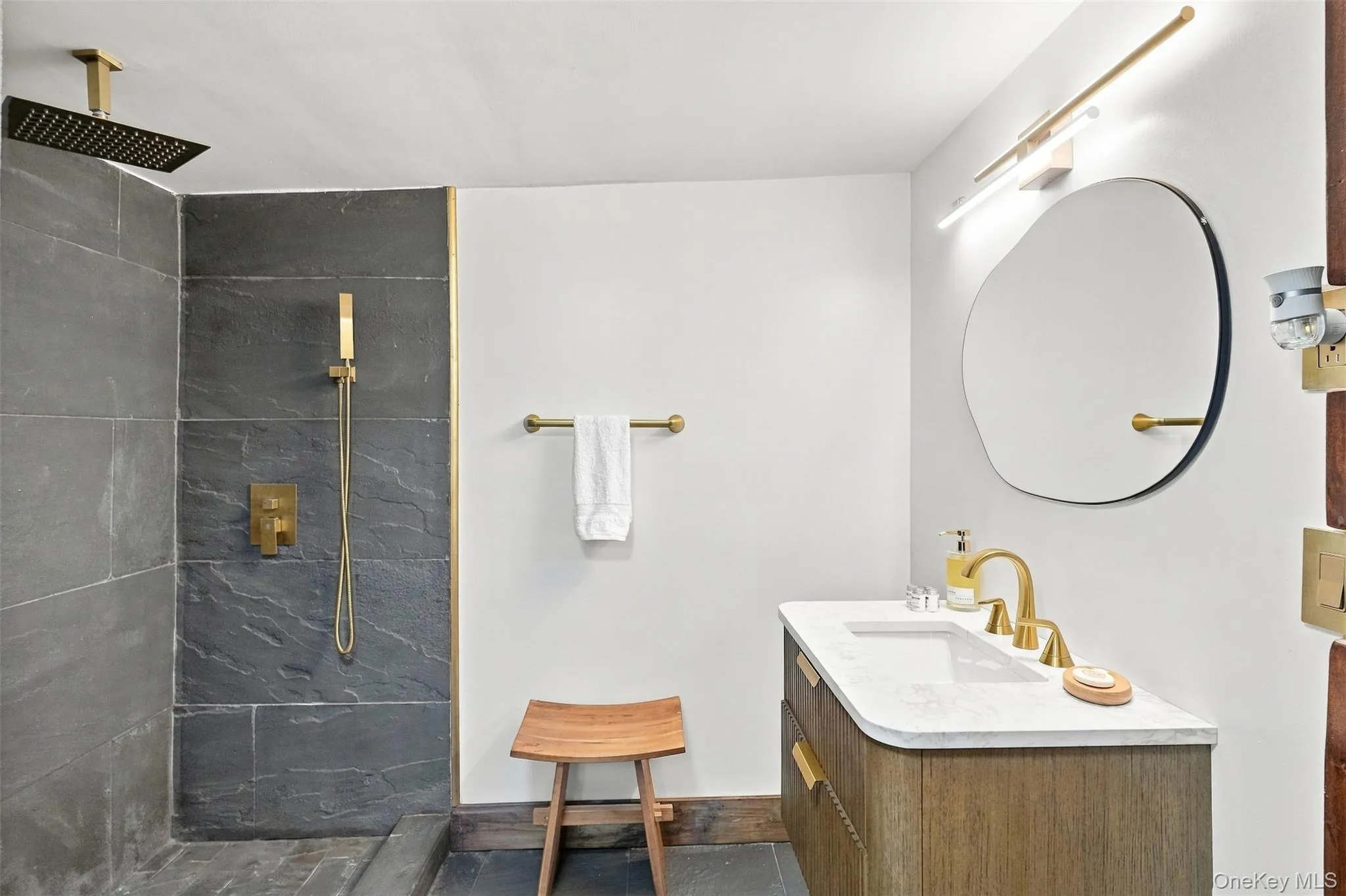 Bluestone walk in shower. Off the bathroom is the laundry room with space for storage Bluestone walk in shower. Off the bathroom is the laundry room with space for storage