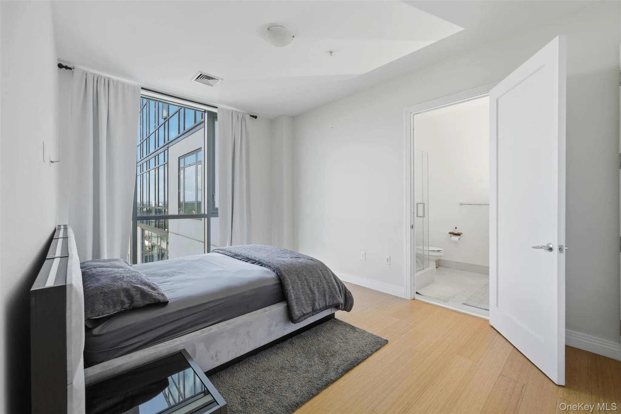 Primary bedroom with full bath and large windows Primary bedroom with full bath and large windows
