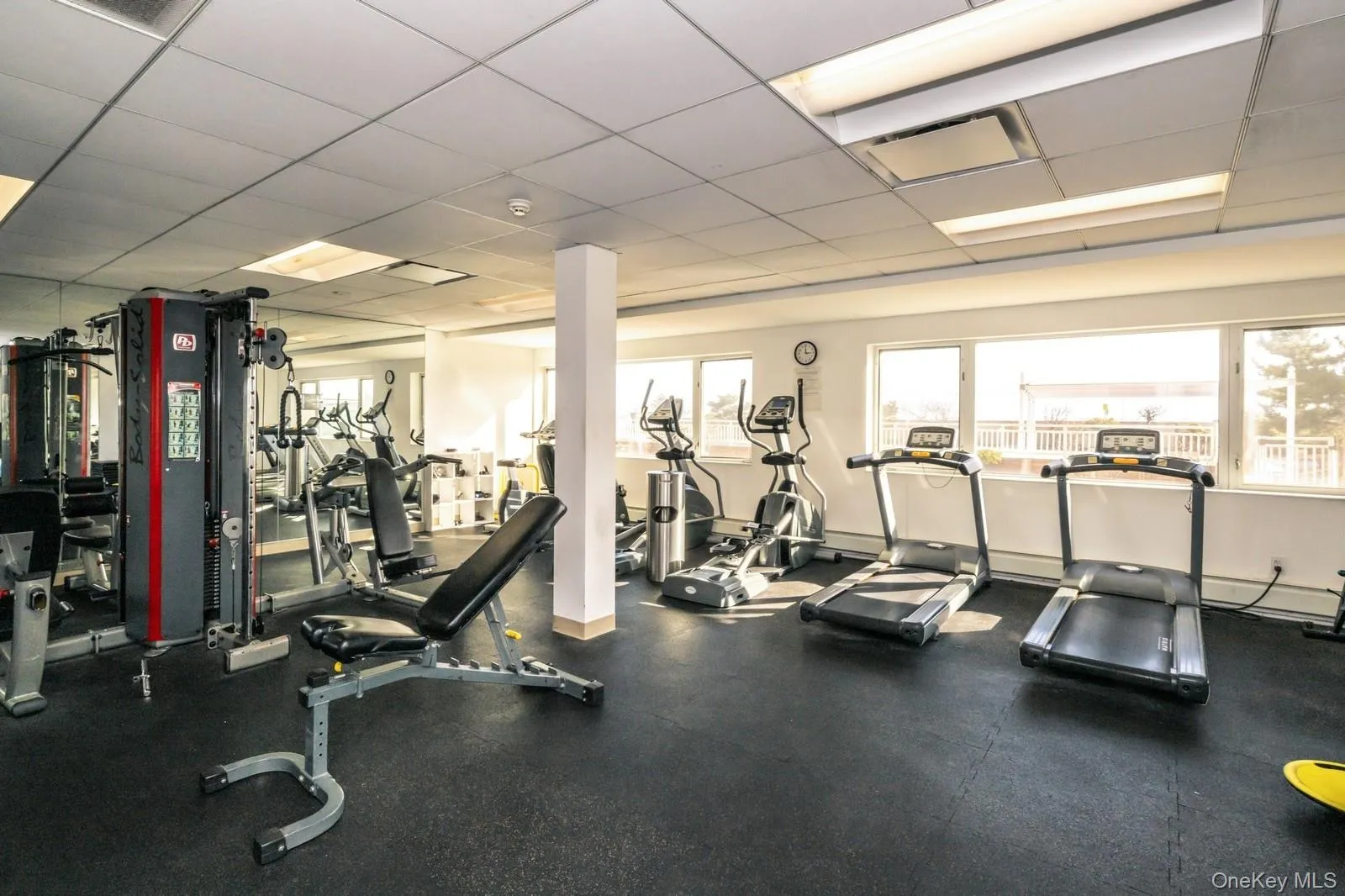 Workout area with visible vents, a wealth of natural light, and a drop ceiling Workout area with visible vents, a wealth of natural light, and a drop ceiling