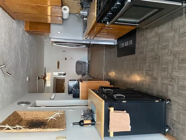 Kitchen with stove, brown cabinets, light countertops, and a sink Kitchen with stove, brown cabinets, light countertops, and a sink