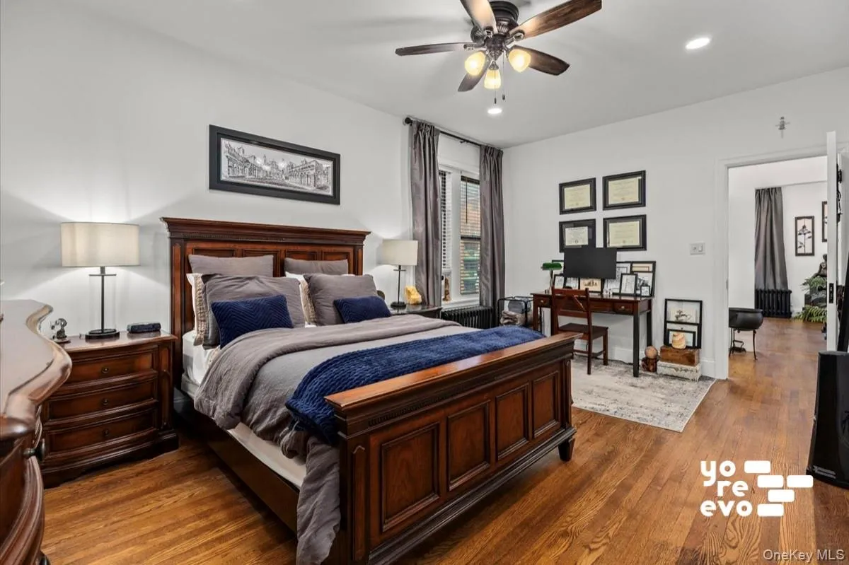 Hardwood flooring, ceiling fan with integrated lighting, recessed lighting, window with blinds, and white wall finishes Hardwood flooring, ceiling fan with integrated lighting, recessed lighting, window with blinds, and white wall finishes