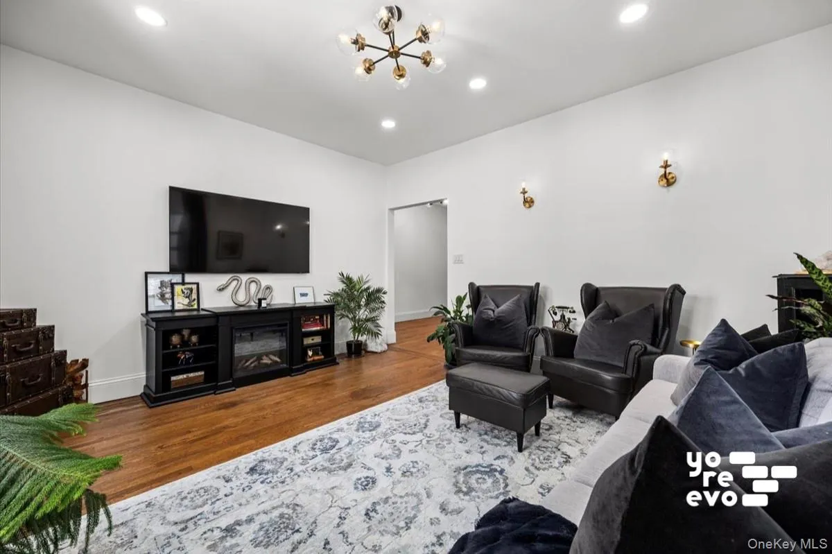 Hardwood flooring, recessed lighting, and a modern chandelier Hardwood flooring, recessed lighting, and a modern chandelier