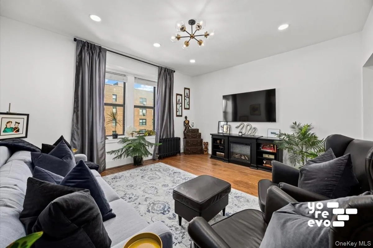 Hardwood flooring, recessed lighting, large windows with black trim, and a contemporary light fixture Hardwood flooring, recessed lighting, large windows with black trim, and a contemporary light fixture