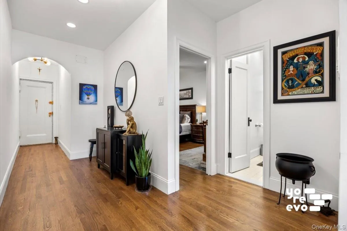 Hardwood flooring, recessed lighting, white trim work, and an arched entryway Hardwood flooring, recessed lighting, white trim work, and an arched entryway
