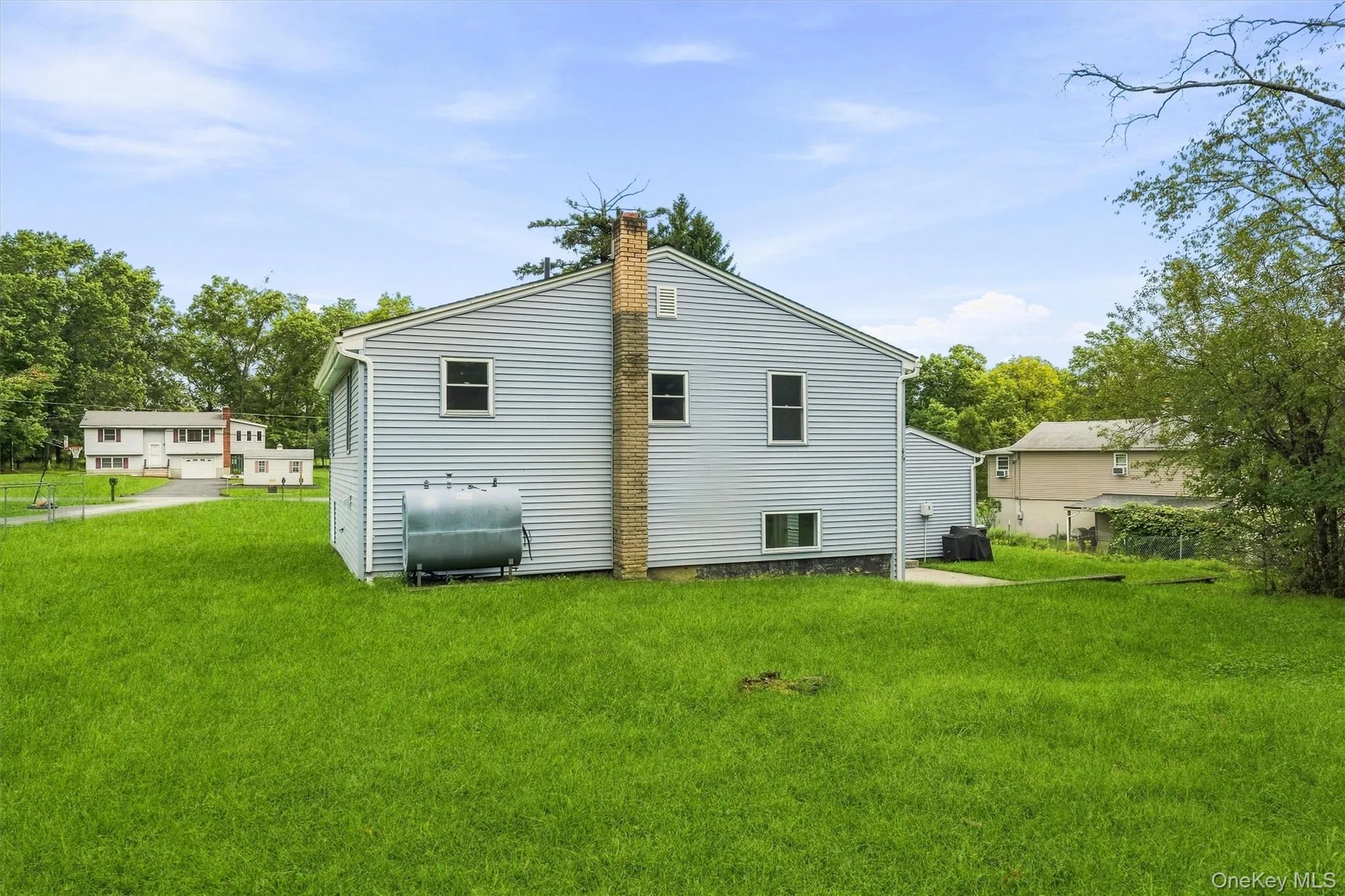 Siding exterior with a brick chimney and a concrete patio Siding exterior with a brick chimney and a concrete patio