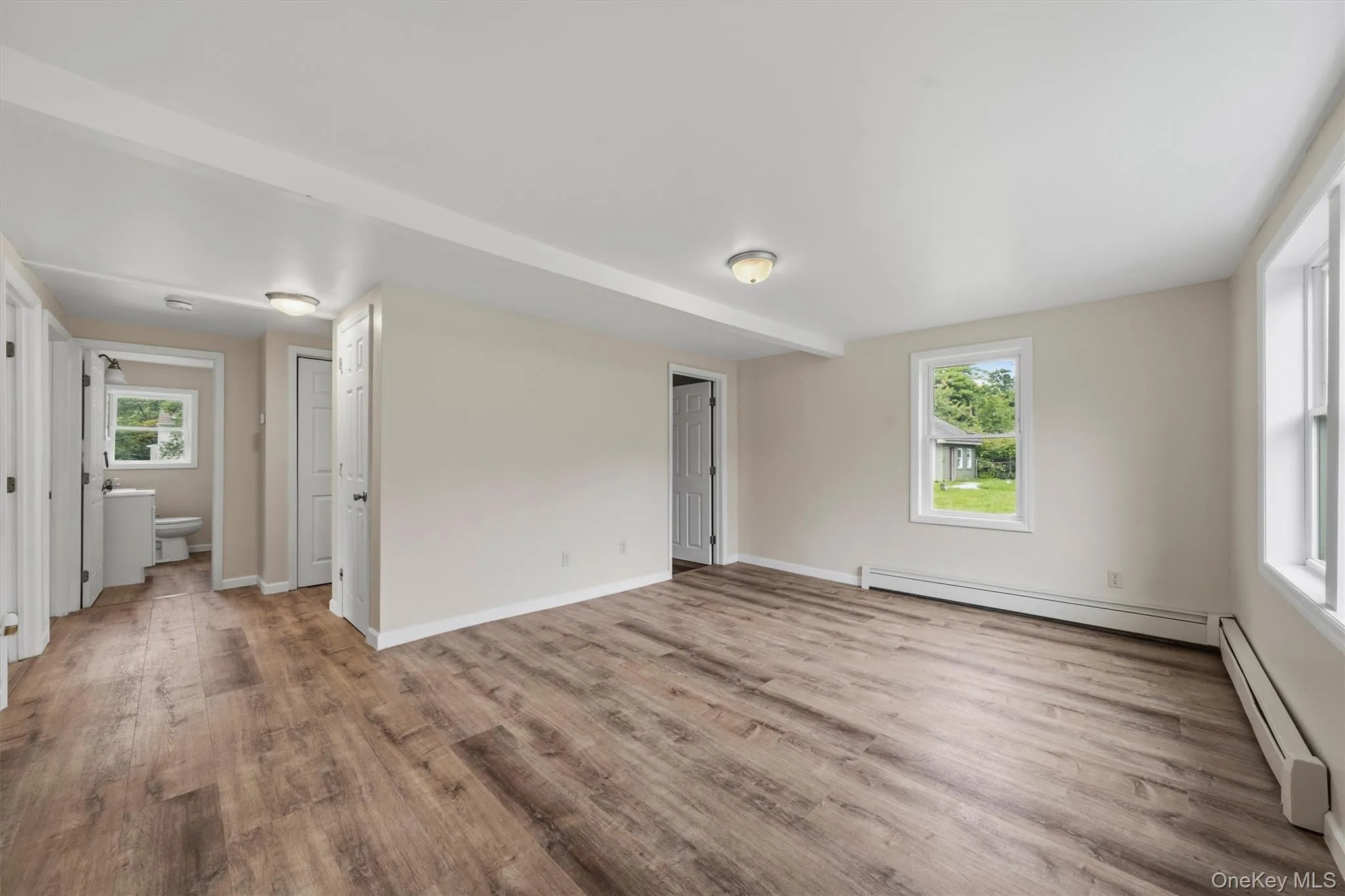 Neutral wall finishes, wood-finish flooring, white trim, recessed lighting, and a white vanity with a rectangular sink Neutral wall finishes, wood-finish flooring, white trim, recessed lighting, and a white vanity with a rectangular sink