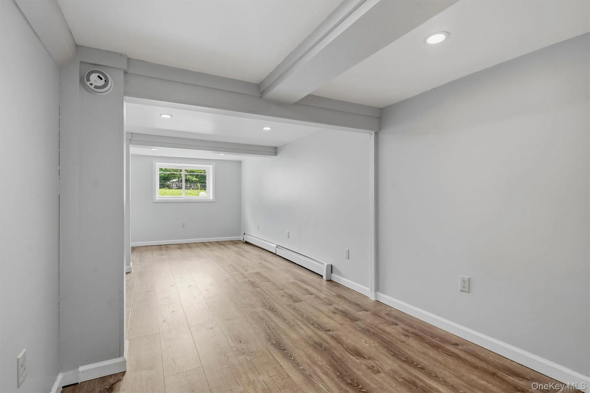 Wood-finish flooring, recessed lighting, and a white window frame Wood-finish flooring, recessed lighting, and a white window frame