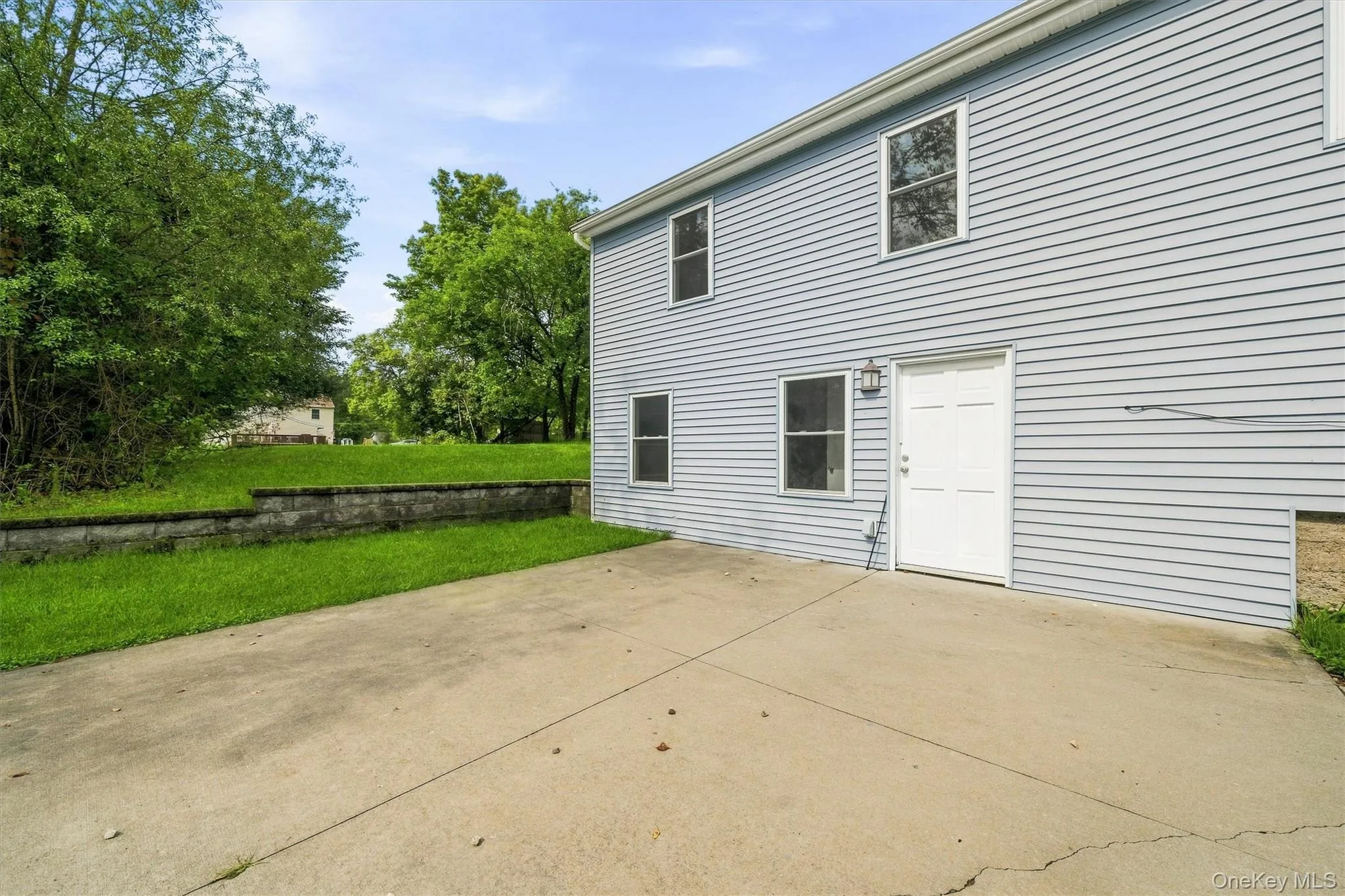 Light blue vinyl siding exterior with white trim windows and a white paneled door Light blue vinyl siding exterior with white trim windows and a white paneled door