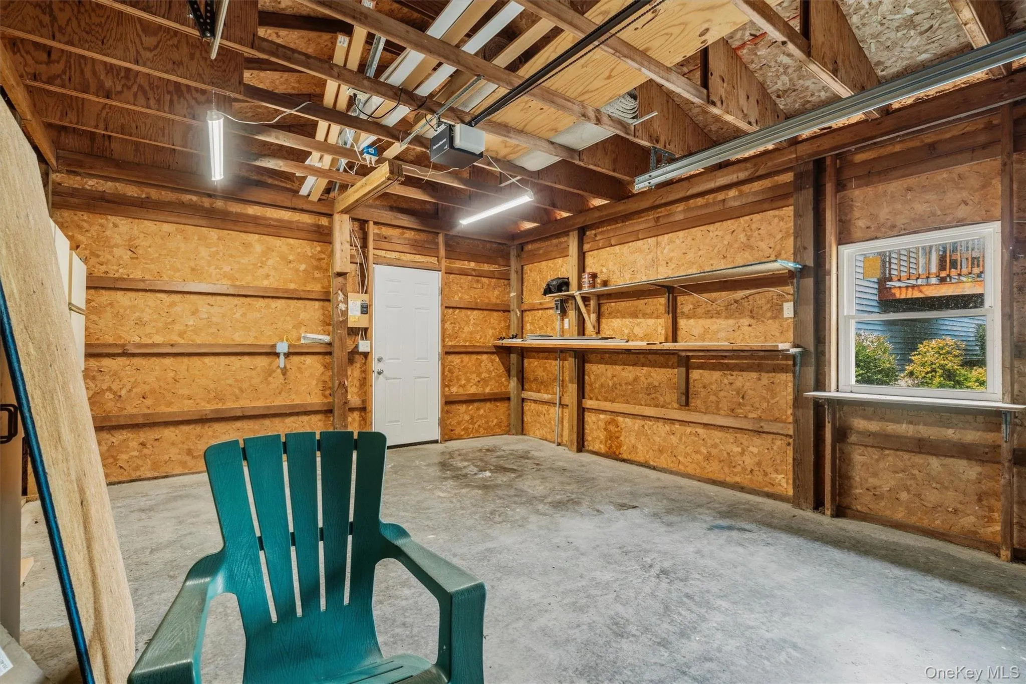 Exposed wood beam ceiling, concrete flooring, interior access door, built-in shelving, and a single window Exposed wood beam ceiling, concrete flooring, interior access door, built-in shelving, and a single window