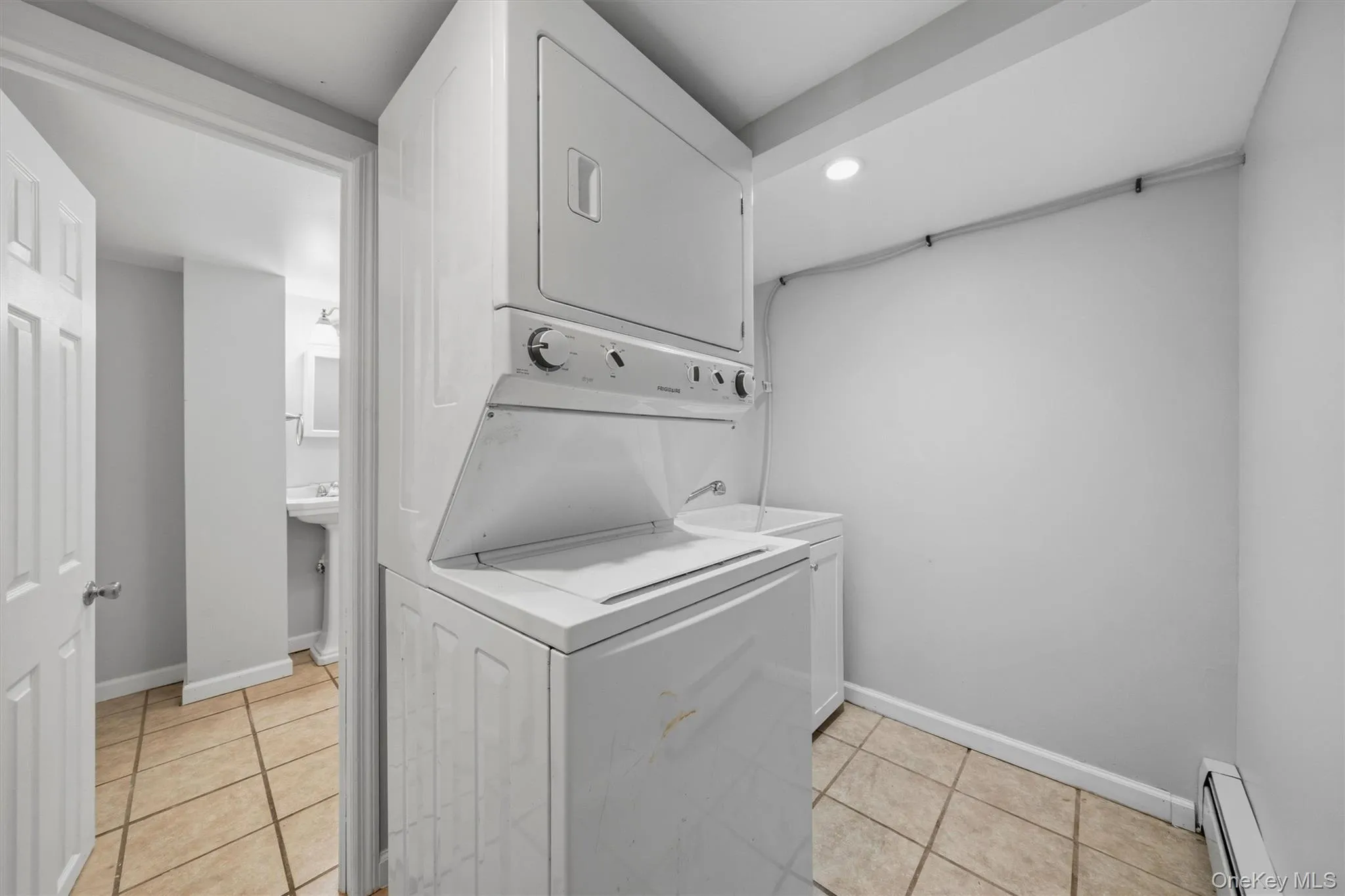 Stacked washer and dryer, utility sink, tile flooring, recessed lighting, baseboard heating Stacked washer and dryer, utility sink, tile flooring, recessed lighting, baseboard heating