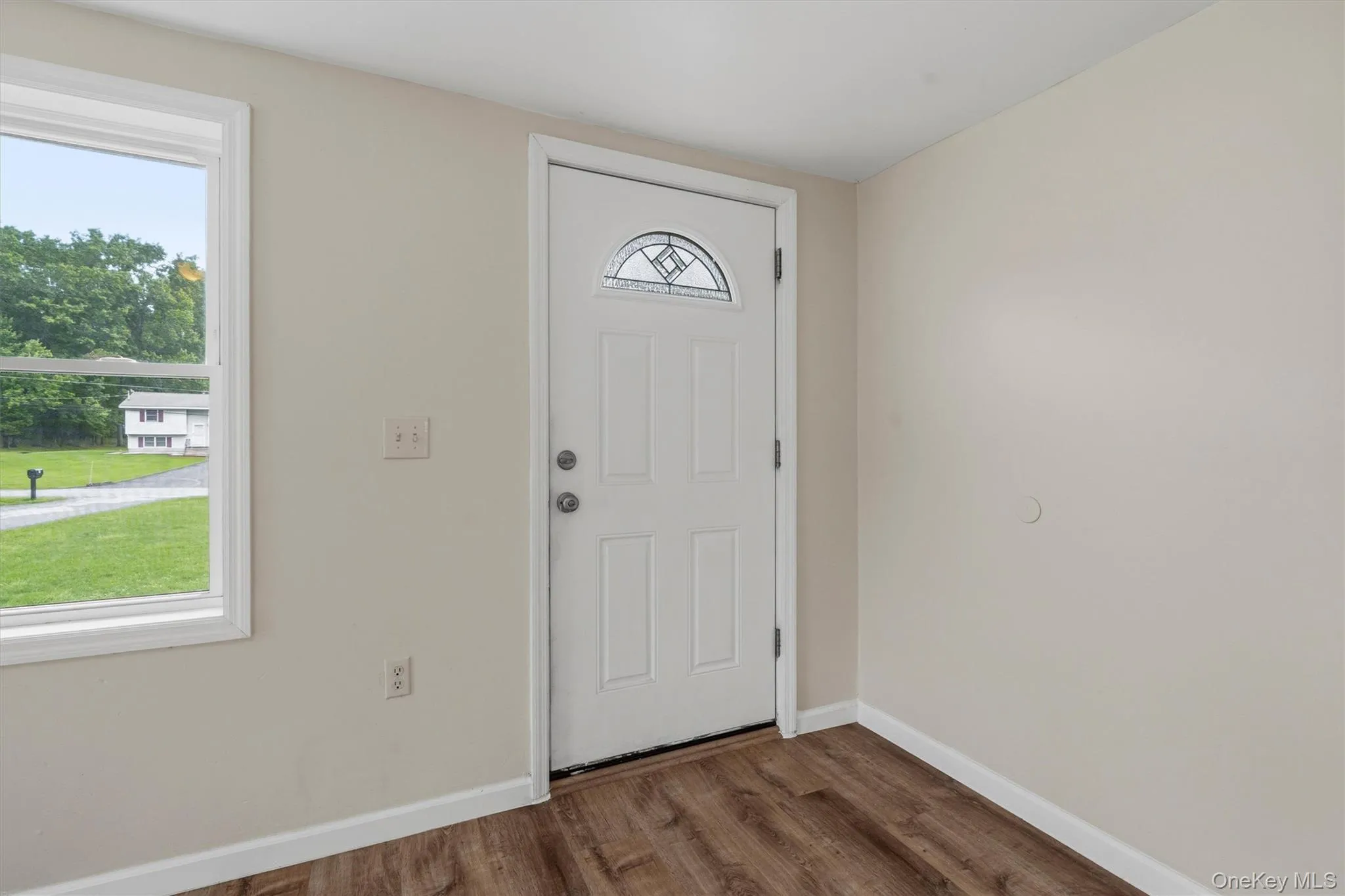 Entry door with decorative glass panel and light-colored walls Entry door with decorative glass panel and light-colored walls