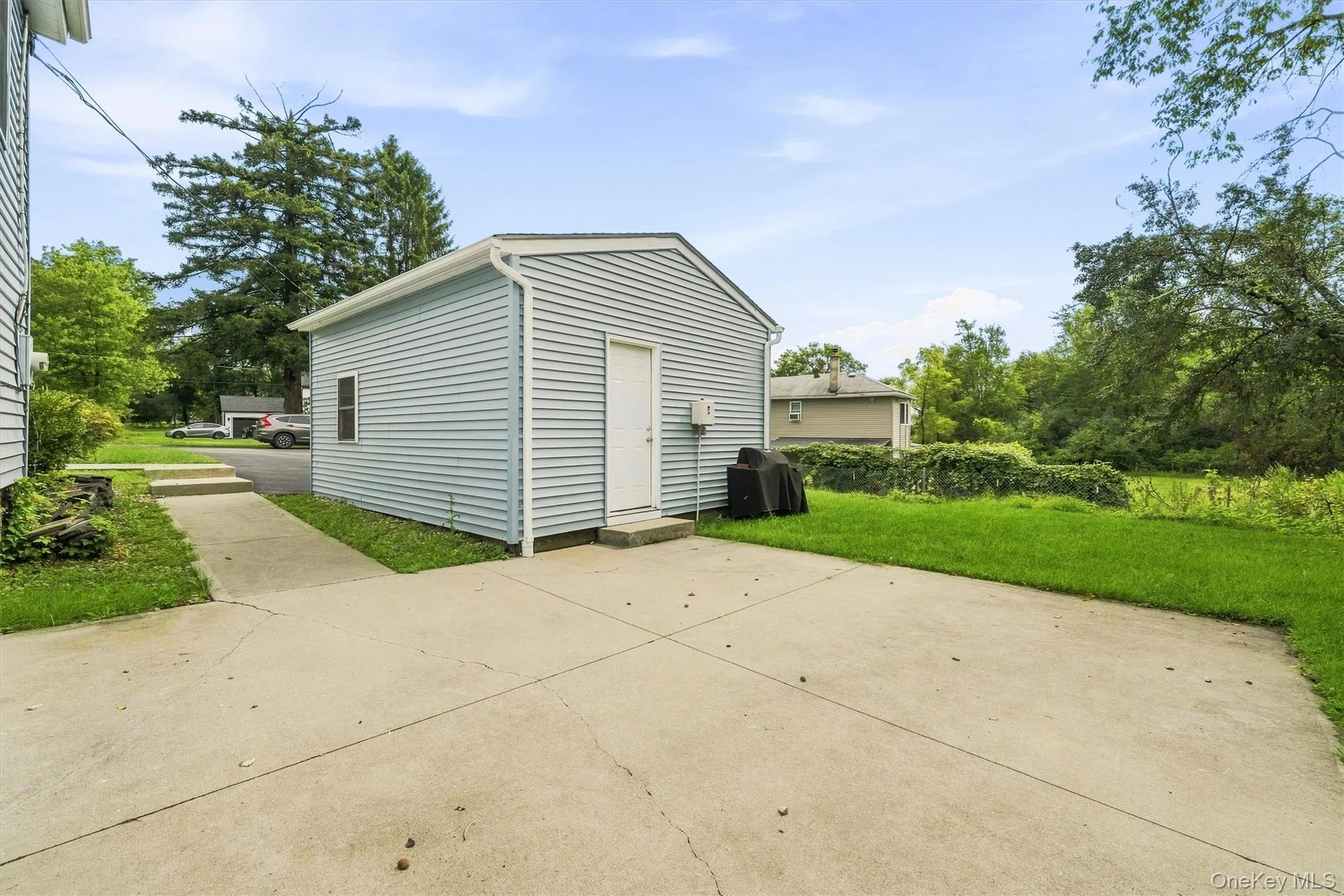 Detached structure with horizontal siding, concrete driveway, and concrete walkway Detached structure with horizontal siding, concrete driveway, and concrete walkway