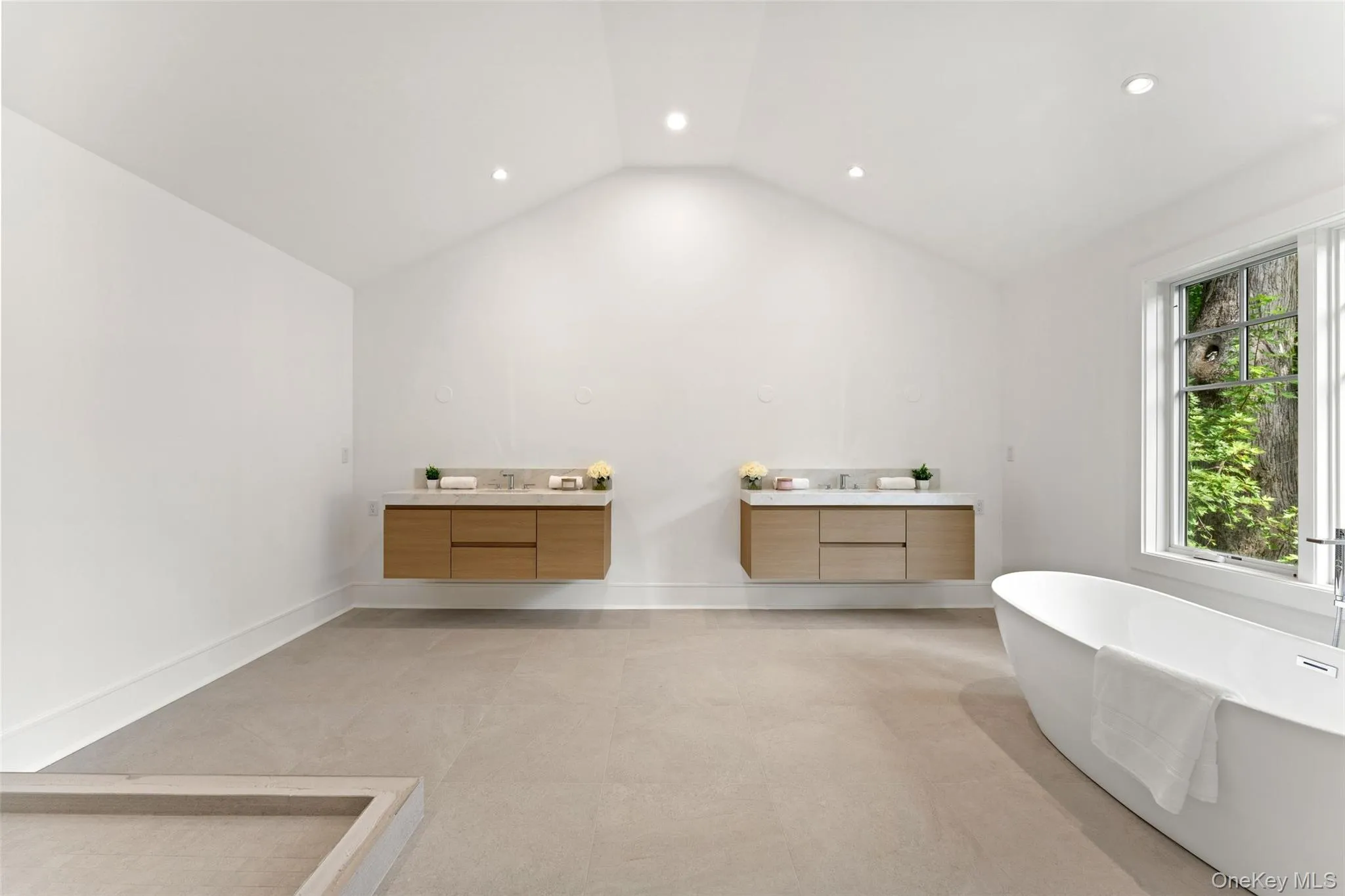 Primary bathroom with double floating vanities and soaking tub Primary bathroom with double floating vanities and soaking tub
