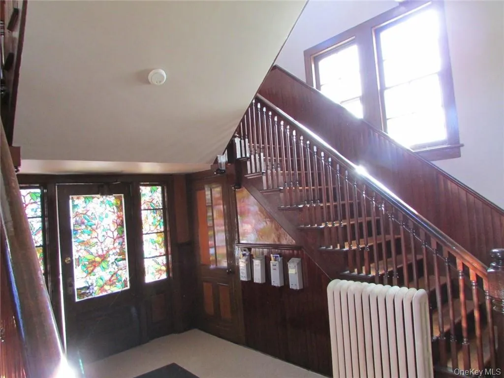 Staircase featuring radiator in foyer of building. Staircase featuring radiator in foyer of building.