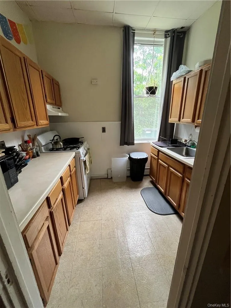 Kitchen with sink, tile patterned flooring, and a paneled ceiling Kitchen with sink, tile patterned flooring, and a paneled ceiling