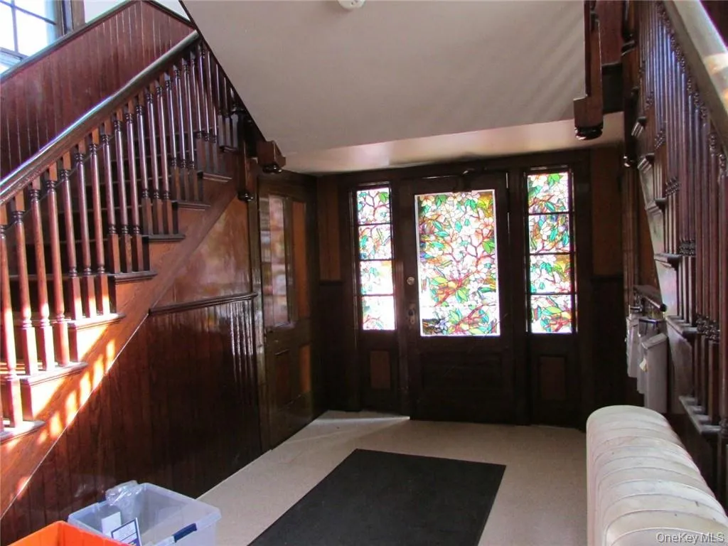 2nd entryway featuring radiator heating unit, a wealth of natural light, and original wood, mail system on the right. 2nd entryway featuring radiator heating unit, a wealth of natural light, and original wood, mail system on the right.