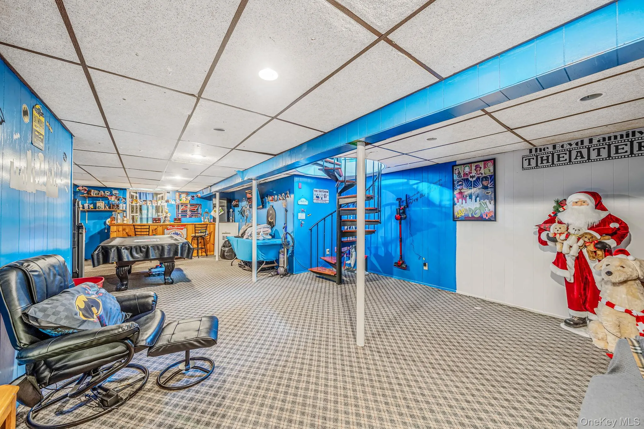 Spacious finished basement with drop ceiling, carpeted flooring, built-in bar, and a spiral staircase Spacious finished basement with drop ceiling, carpeted flooring, built-in bar, and a spiral staircase