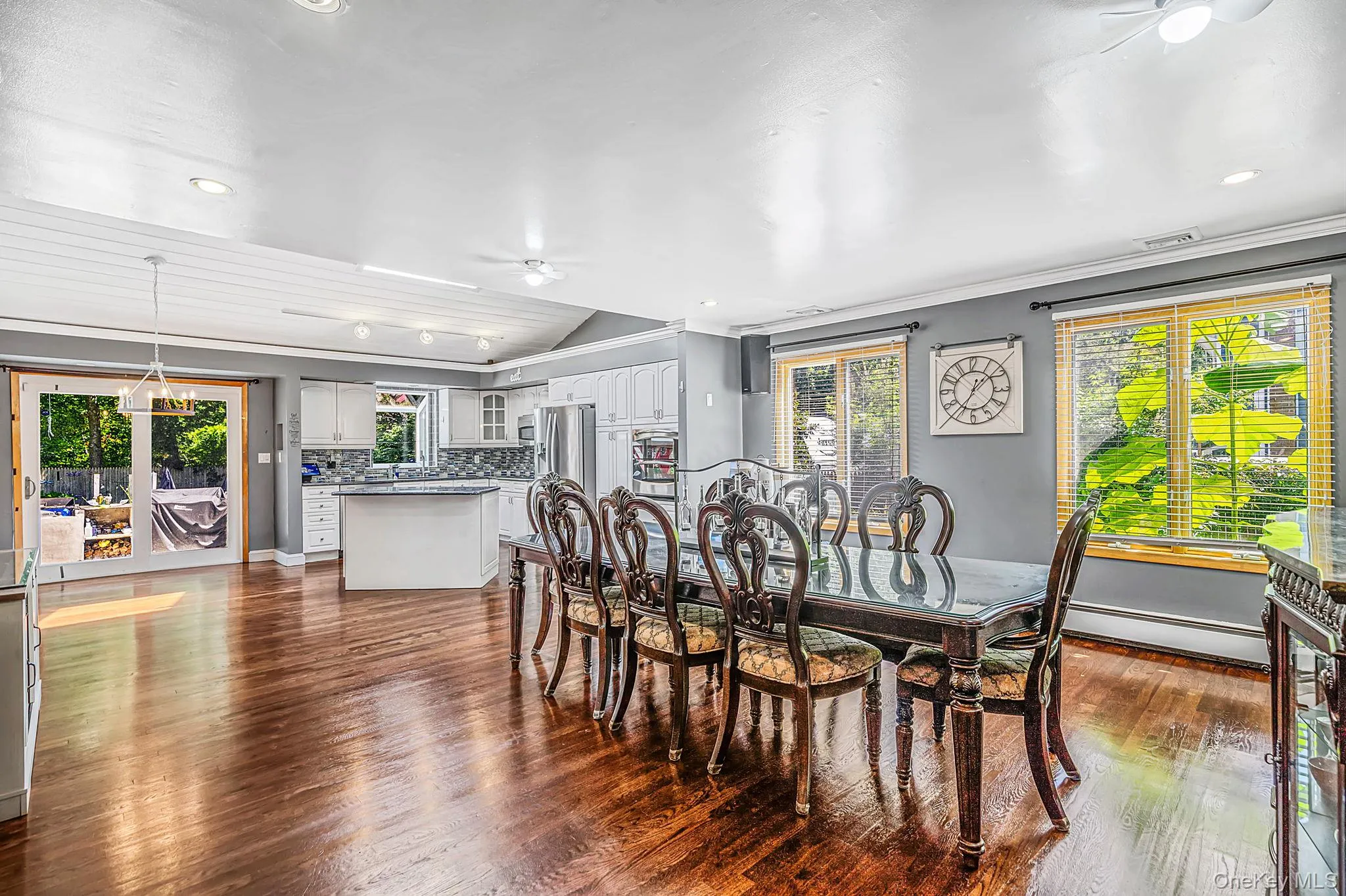 Open-concept living space featuring wood-finish flooring, recessed lighting, and a vaulted shiplap ceiling Open-concept living space featuring wood-finish flooring, recessed lighting, and a vaulted shiplap ceiling
