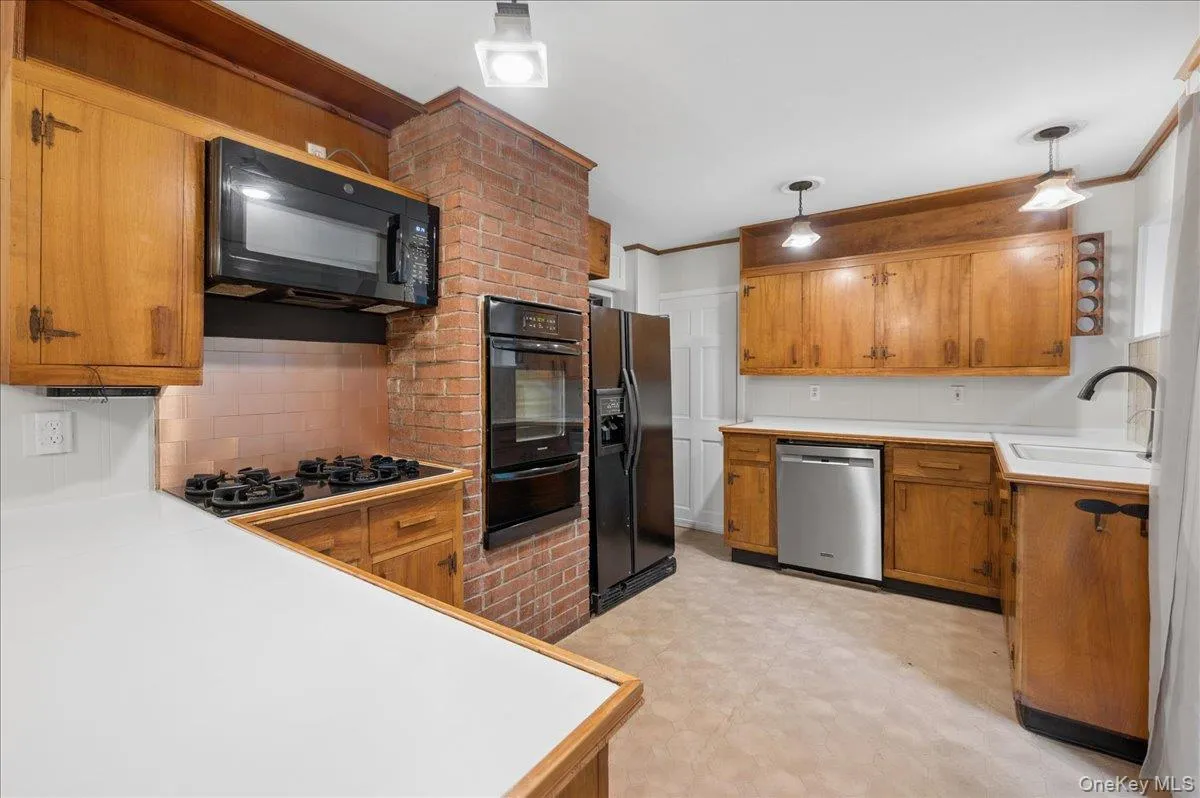 Lower level kitchen view with built in oven, microwave, gas cooktop and refrigerator Lower level kitchen view with built in oven, microwave, gas cooktop and refrigerator
