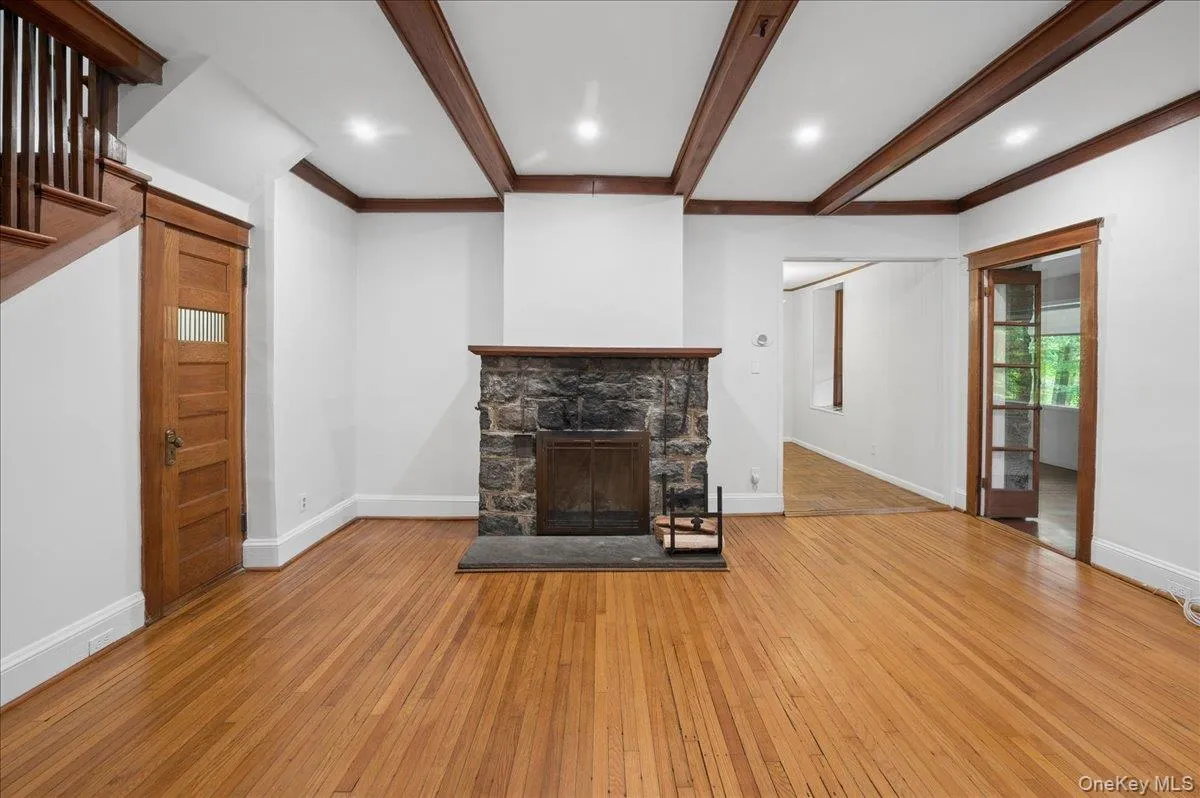 Lower level living room with wood burning fireplace with entrance to dining room and four season porch Lower level living room with wood burning fireplace with entrance to dining room and four season porch