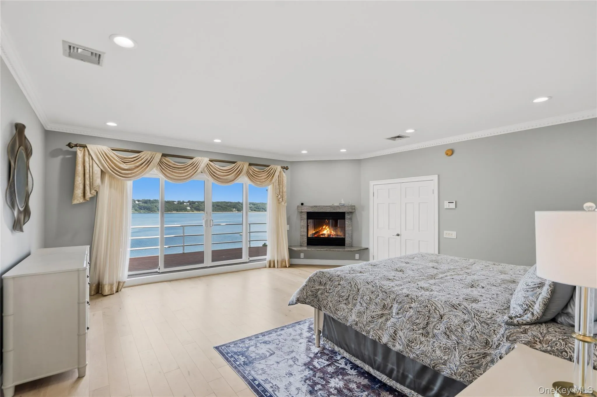 Primary Bedroom with fireplace, balcony and water views Primary Bedroom with fireplace, balcony and water views