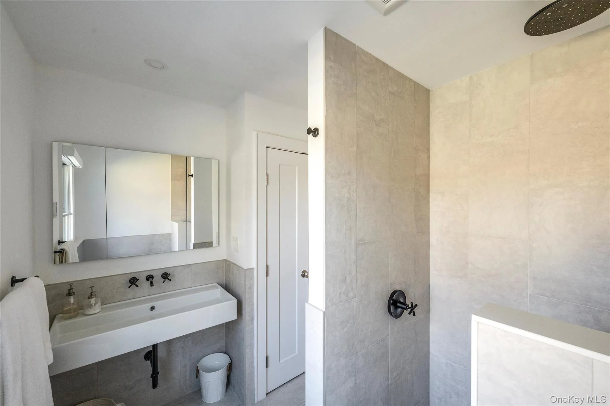 Full bath with a walk in shower, a sink, and tile walls Full bath with a walk in shower, a sink, and tile walls