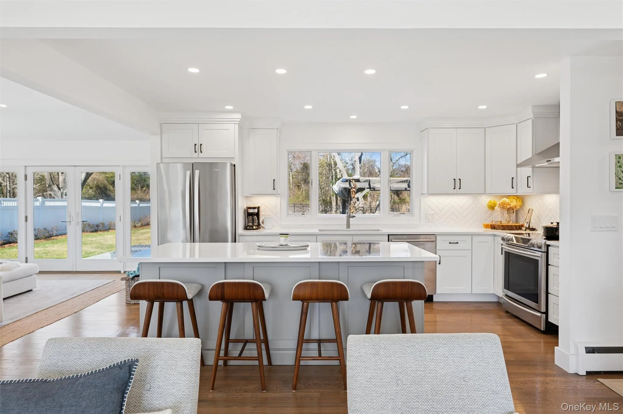 Kitchen with decorative backsplash, a center island, recessed lighting, and stainless steel appliances Kitchen with decorative backsplash, a center island, recessed lighting, and stainless steel appliances