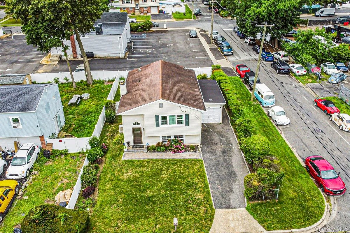 Charming cottage-style residence featuring a pitched roof with dimensional shingle detailing, white exterior siding, and green shutters Charming cottage-style residence featuring a pitched roof with dimensional shingle detailing, white exterior siding, and green shutters