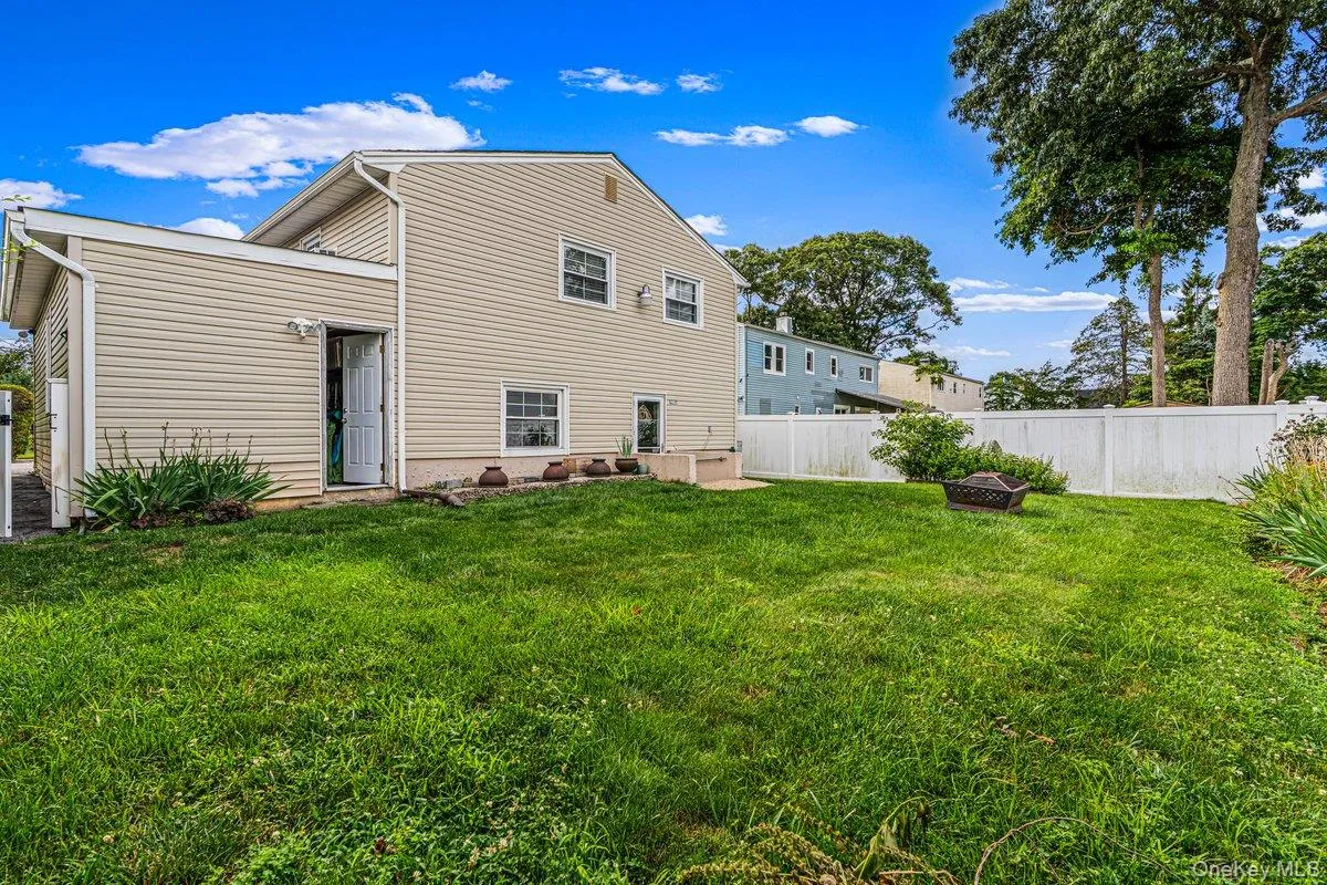 Expansive green lawn, white picket fence, large shade trees, and vinyl siding exterior Expansive green lawn, white picket fence, large shade trees, and vinyl siding exterior