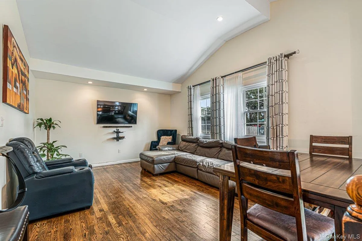 Vaulted ceiling with recessed lighting, wood-finish flooring, and multiple windows Vaulted ceiling with recessed lighting, wood-finish flooring, and multiple windows