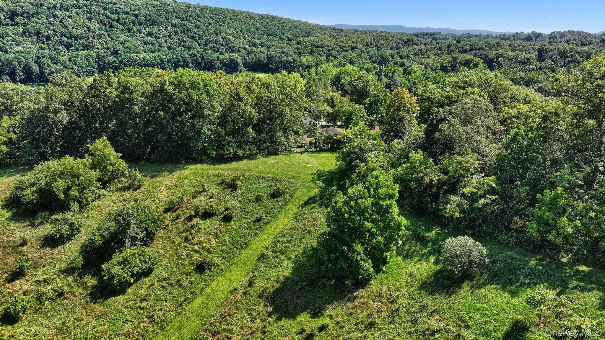 Aerial view of property and surrounding area with a forest Aerial view of property and surrounding area with a forest