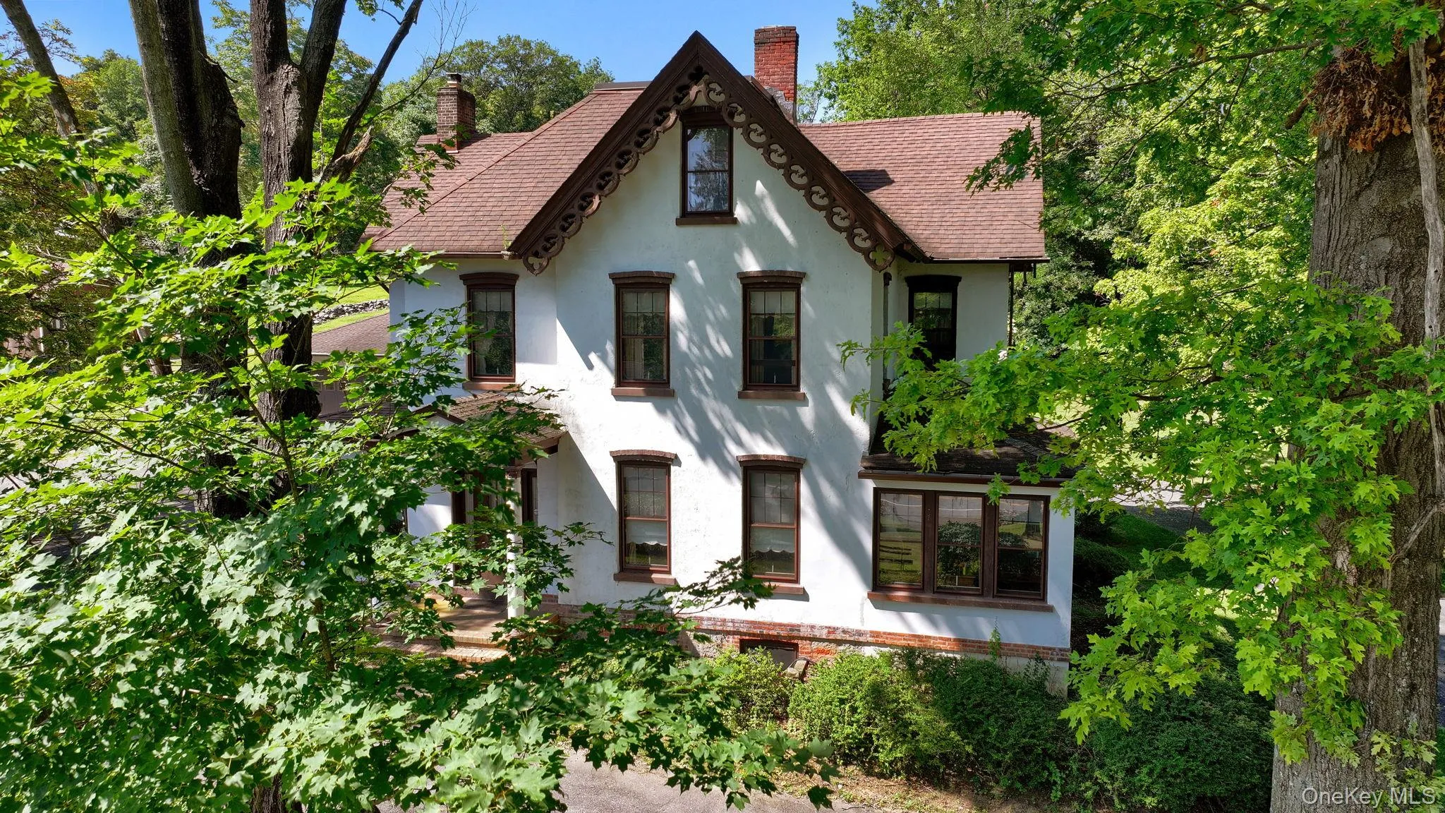 Tudor house with stucco siding, roof with shingles, and a chimney Tudor house with stucco siding, roof with shingles, and a chimney