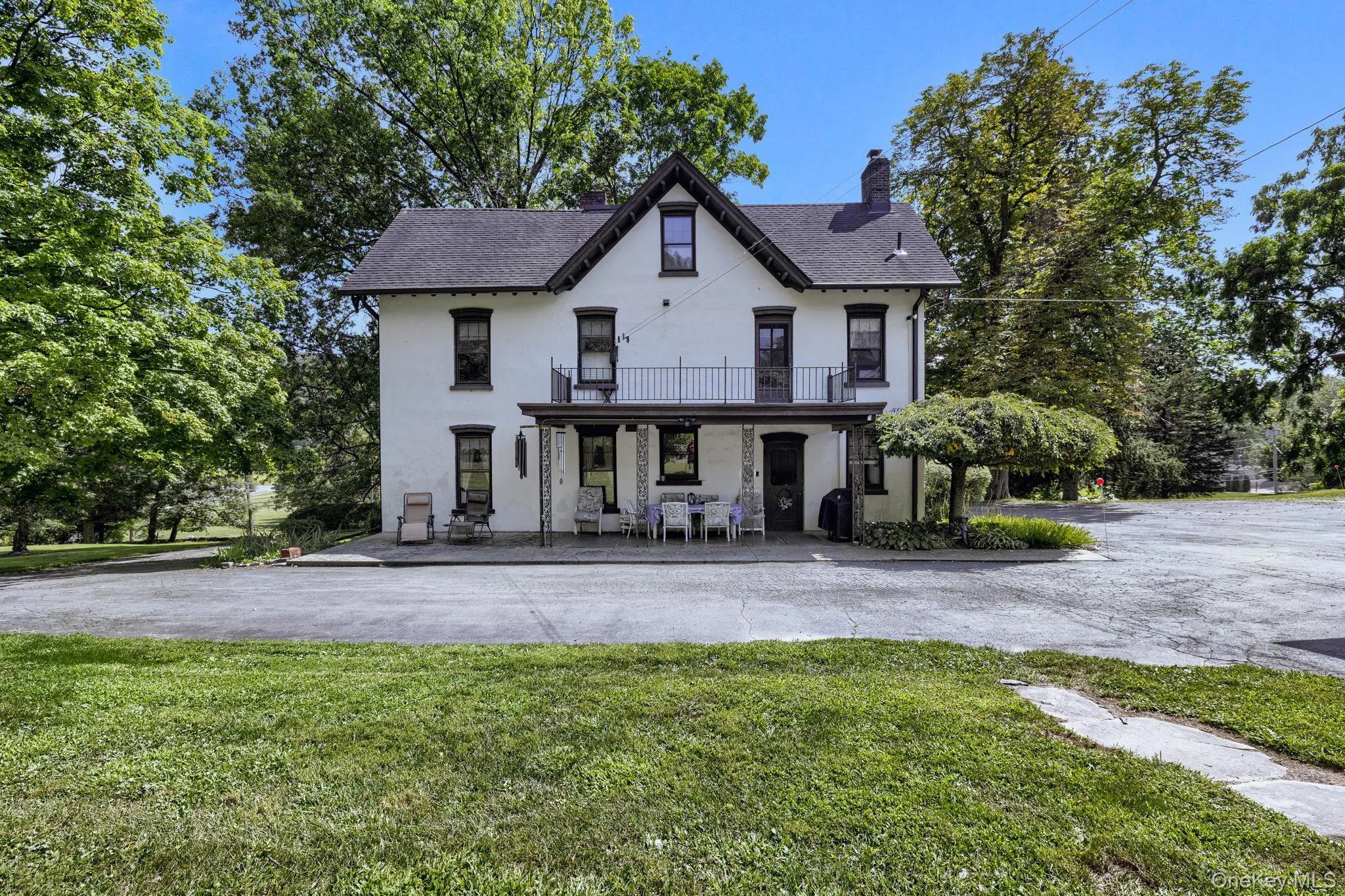 View of front facade with stucco siding, a chimney, a front yard, and a shingled roof View of front facade with stucco siding, a chimney, a front yard, and a shingled roof