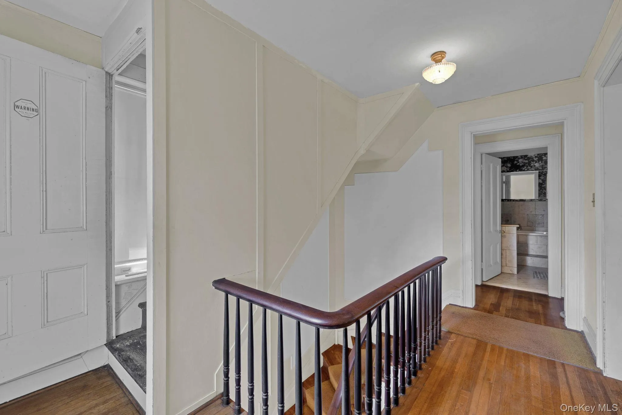 Corridor with wood finished floors and an upstairs landing Corridor with wood finished floors and an upstairs landing