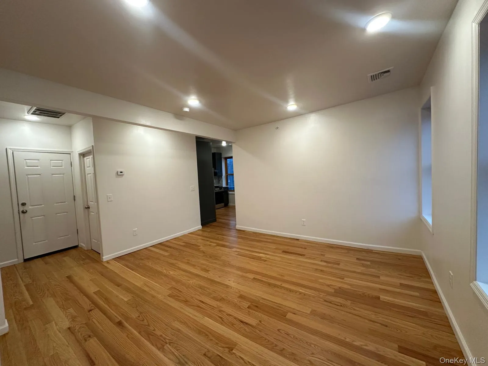 Hardwood flooring, recessed lighting, white trim, and neutral wall tones Hardwood flooring, recessed lighting, white trim, and neutral wall tones
