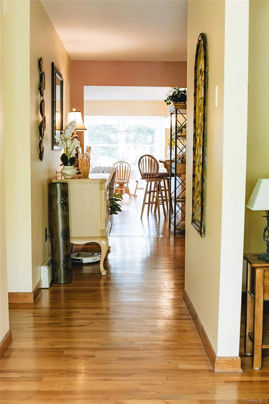 Hardwood flooring throughout, with a wide doorway opening into a sunlit interior Hardwood flooring throughout, with a wide doorway opening into a sunlit interior