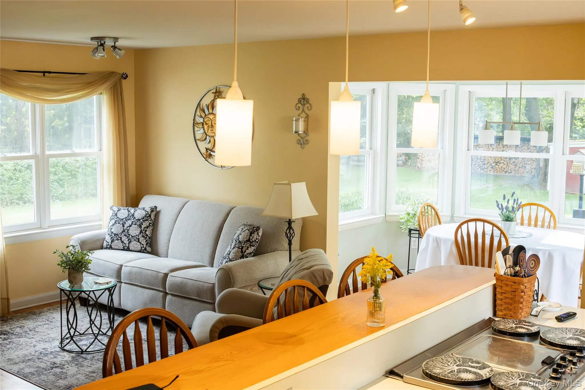 Open-concept living space featuring a wood-finish breakfast bar, any many windows bringing in natural light. Open-concept living space featuring a wood-finish breakfast bar, any many windows bringing in natural light.