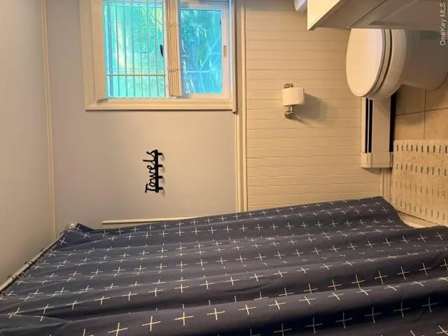 Bathroom featuring ceramic tile flooring, wainscoting, and a window with blinds Bathroom featuring ceramic tile flooring, wainscoting, and a window with blinds