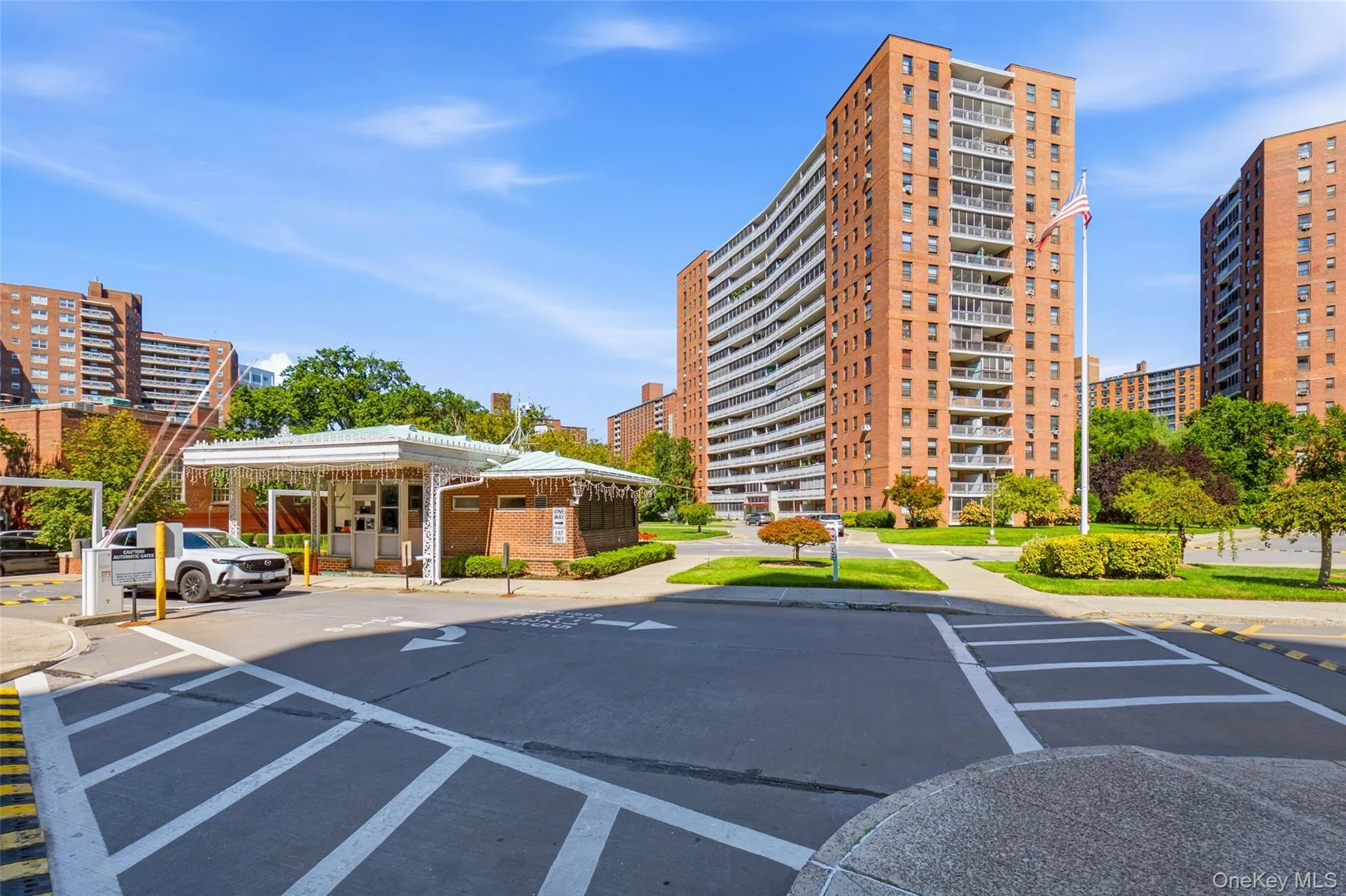 Brick-clad high-rise buildings with multiple balconies, a dedicated entry gate, and landscaped grounds Brick-clad high-rise buildings with multiple balconies, a dedicated entry gate, and landscaped grounds