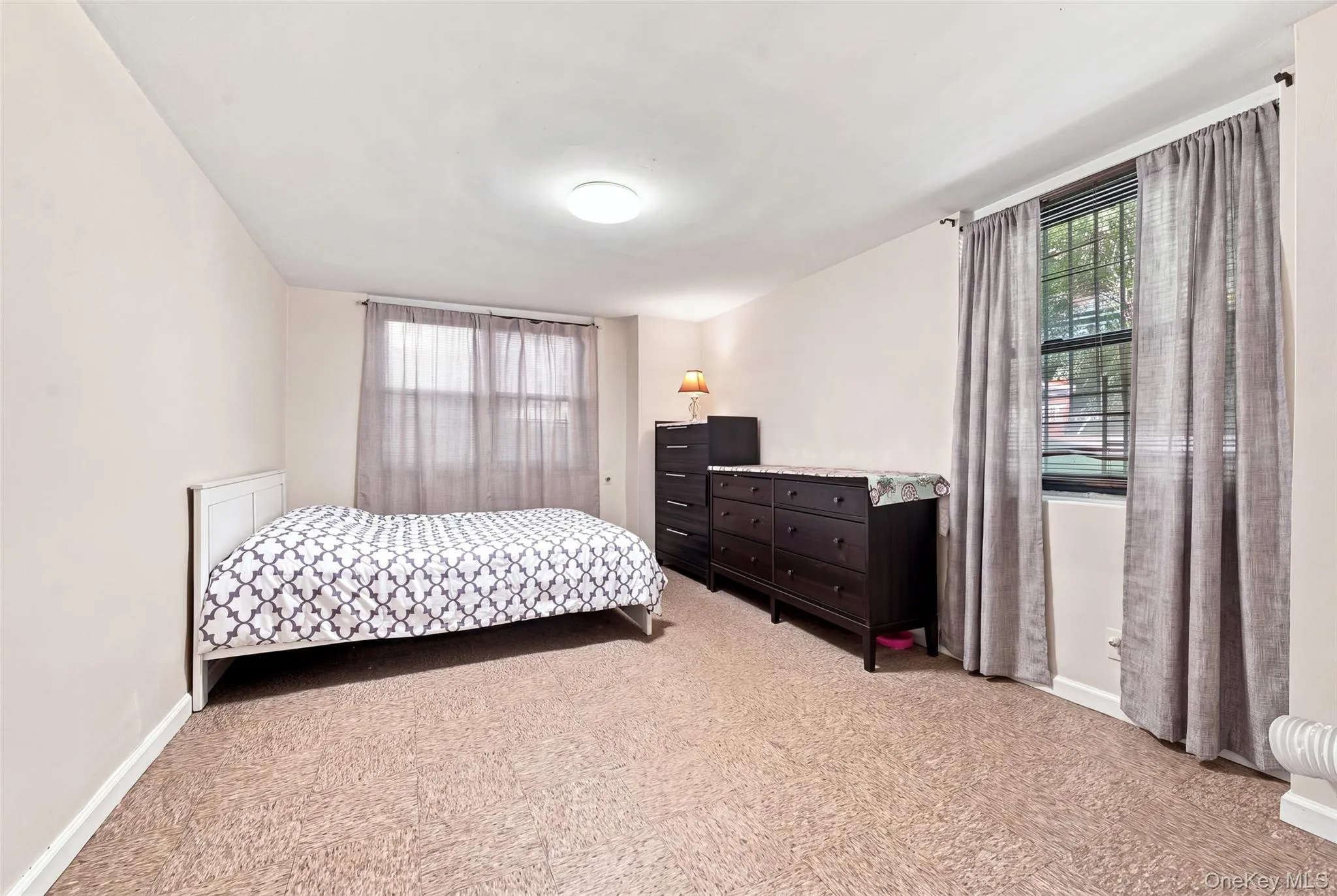 Neutral wall paint, textured carpeting, and two windows with blinds Neutral wall paint, textured carpeting, and two windows with blinds