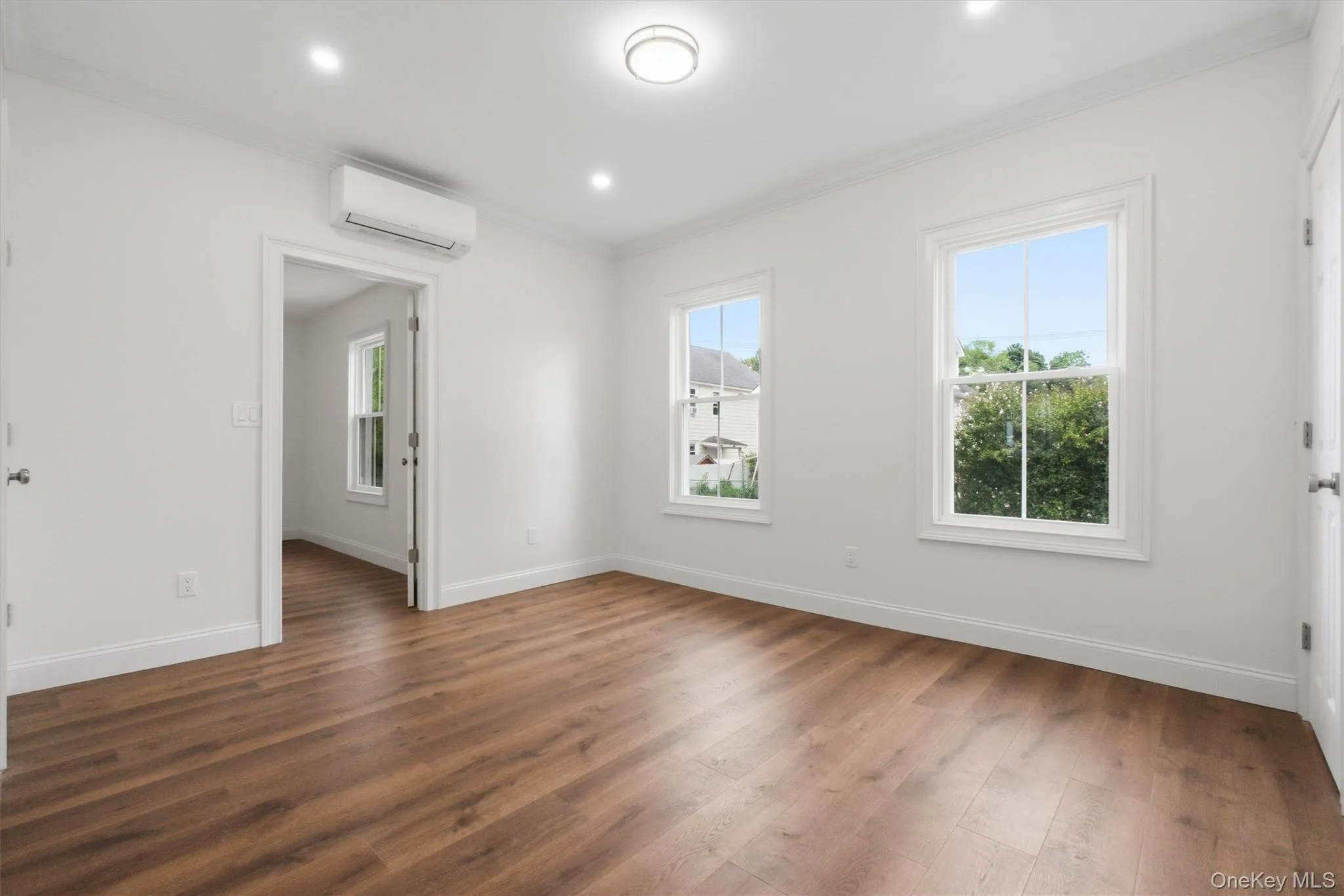 Wood-finish flooring, recessed lighting, and wall-mounted air conditioning unit Wood-finish flooring, recessed lighting, and wall-mounted air conditioning unit