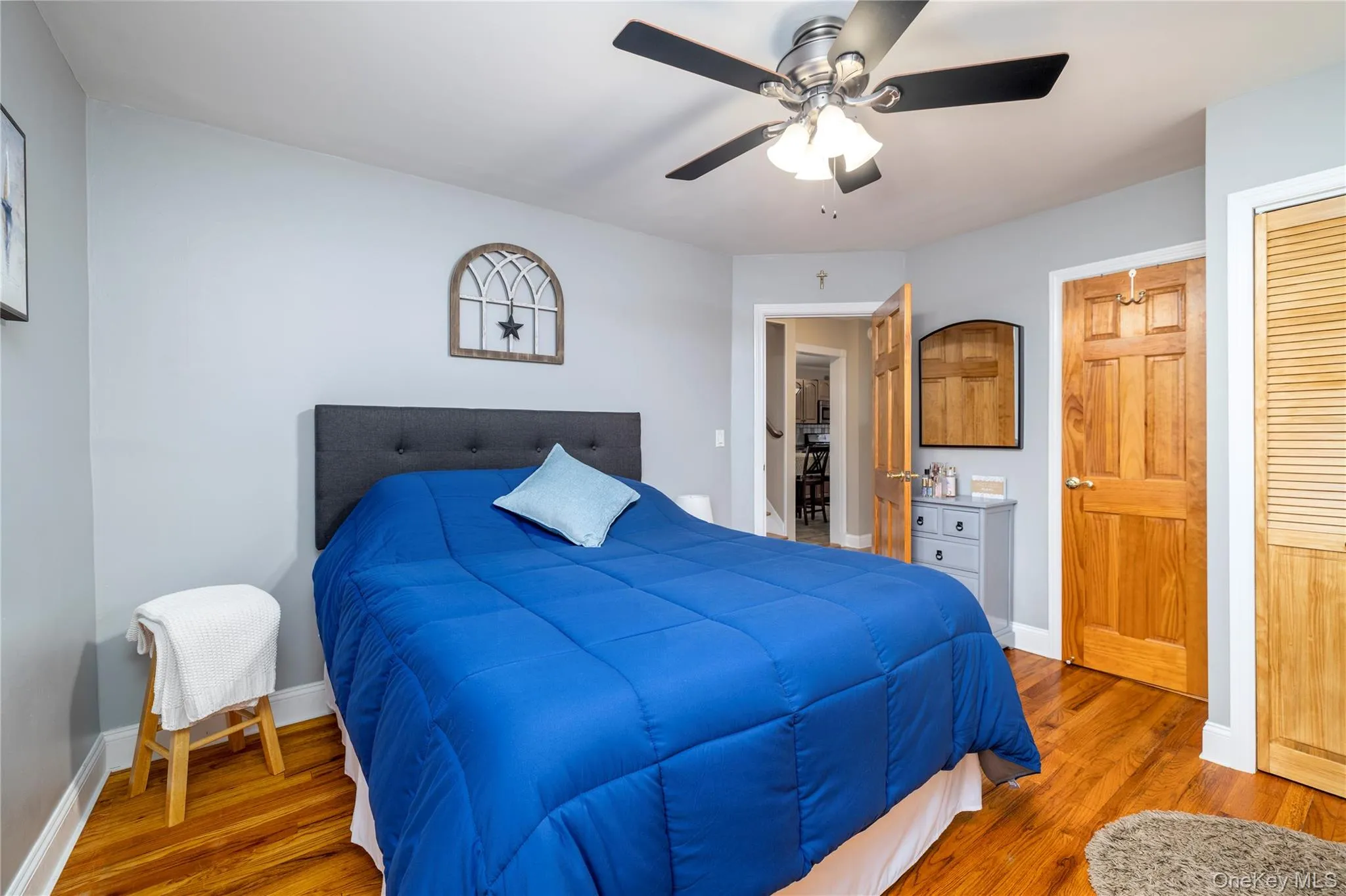 Bedroom featuring a ceiling fan, a closet, baseboards, and wood finished floors Bedroom featuring a ceiling fan, a closet, baseboards, and wood finished floors
