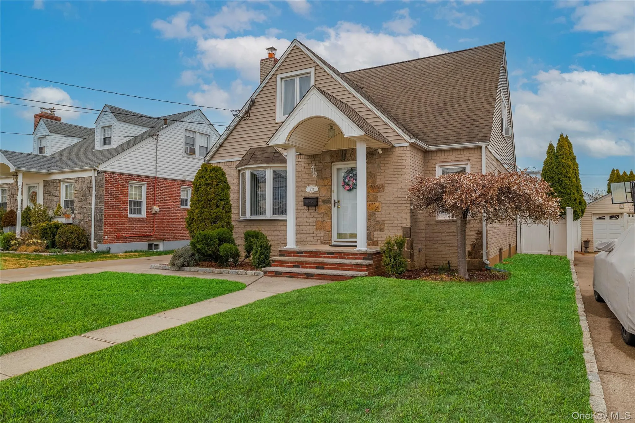 View of front facade with roof with shingles, a chimney, fence, brick siding, and a front lawn View of front facade with roof with shingles, a chimney, fence, brick siding, and a front lawn