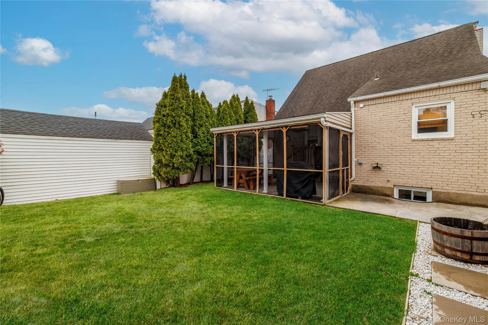 View of yard featuring a sunroom and a patio area View of yard featuring a sunroom and a patio area