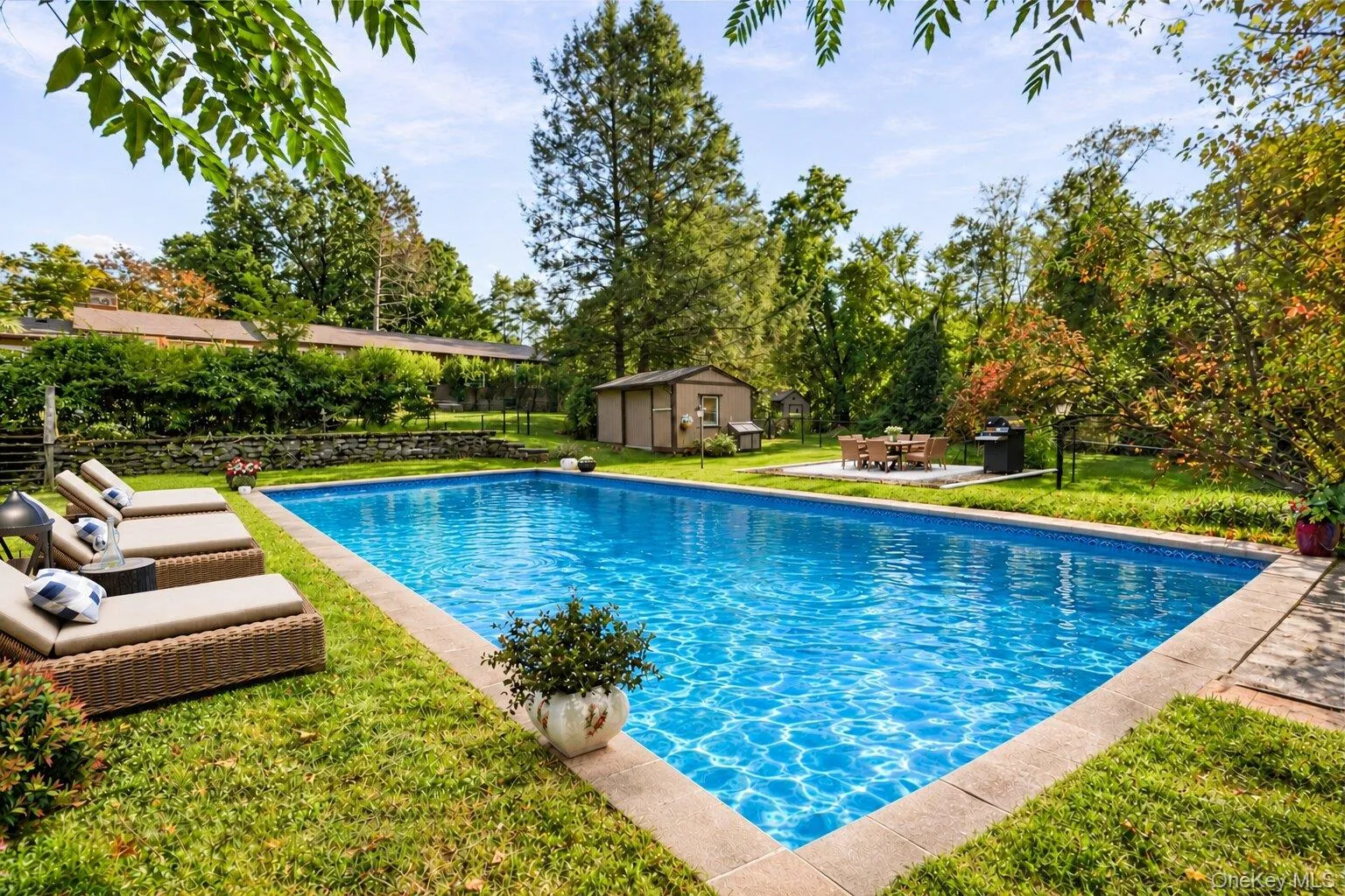 Virtually staged pool area showcasing lounge seating, outdoor dining, and the property’s private landscaped setting Virtually staged pool area showcasing lounge seating, outdoor dining, and the property’s private landscaped setting