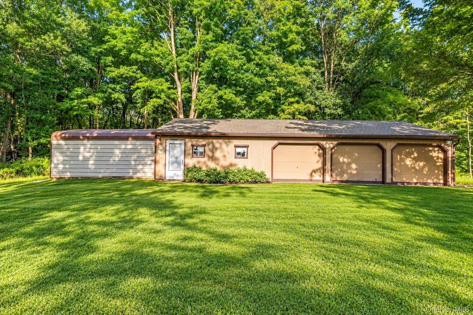 Virtually enhanced exterior view highlighting the detached garage, multiple bays, and spacious surrounding grounds. Virtually enhanced exterior view highlighting the detached garage, multiple bays, and spacious surrounding grounds.