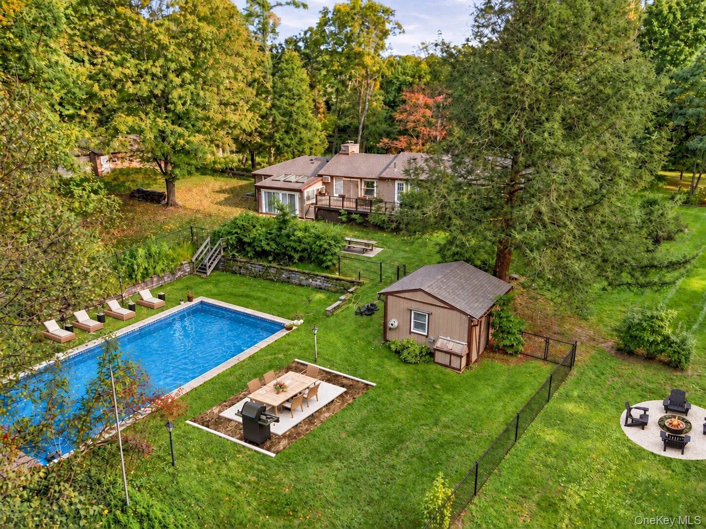 Virtually enhanced aerial view highlighting the pool, entertaining areas, fire pit, and generous backyard setting. Virtually enhanced aerial view highlighting the pool, entertaining areas, fire pit, and generous backyard setting.