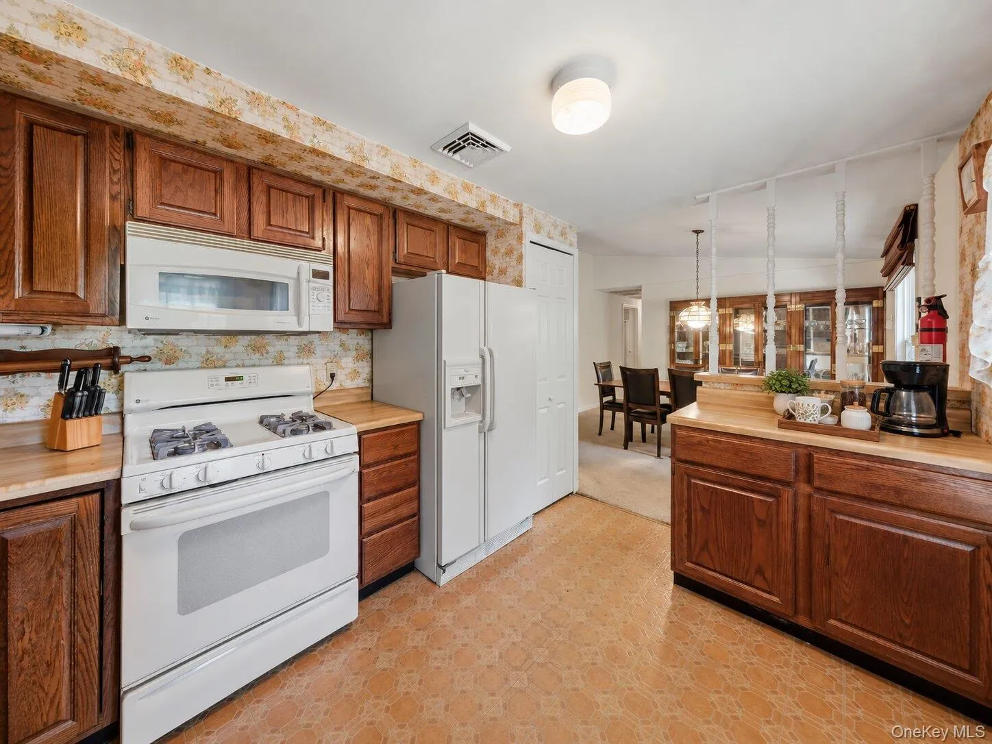 Bright kitchen featuring generous cabinet storage, a breakfast counter, and easy flow to the dining room. Bright kitchen featuring generous cabinet storage, a breakfast counter, and easy flow to the dining room.