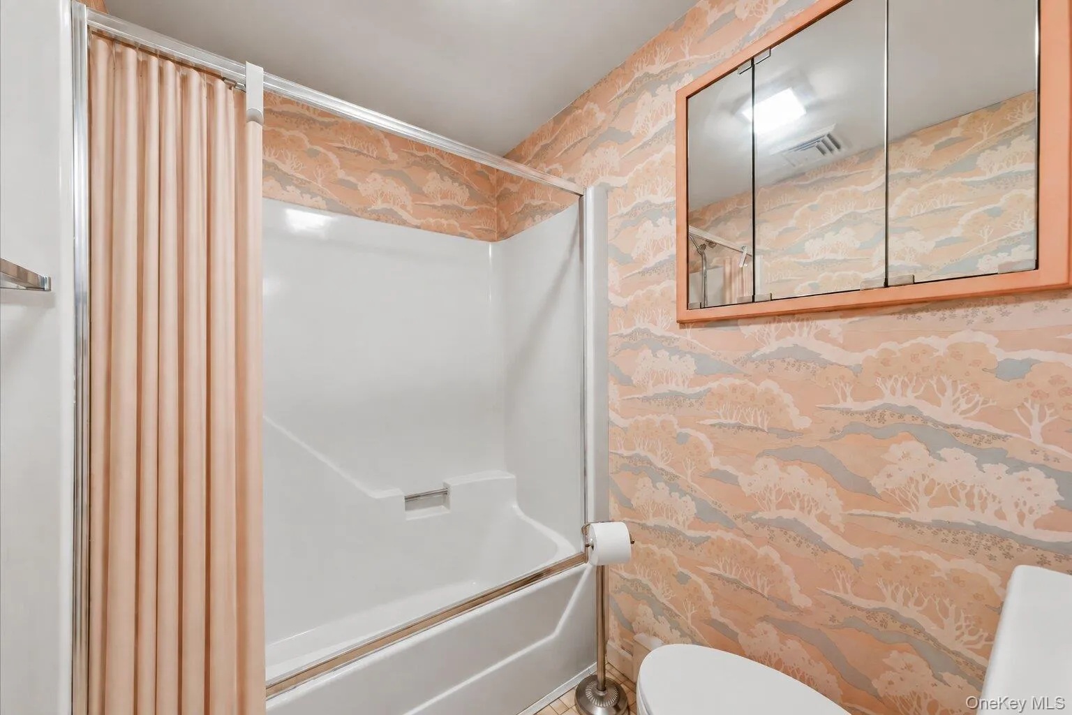Full bathroom featuring a tub/shower combination, mirrored medicine cabinet, and practical layout. Full bathroom featuring a tub/shower combination, mirrored medicine cabinet, and practical layout.